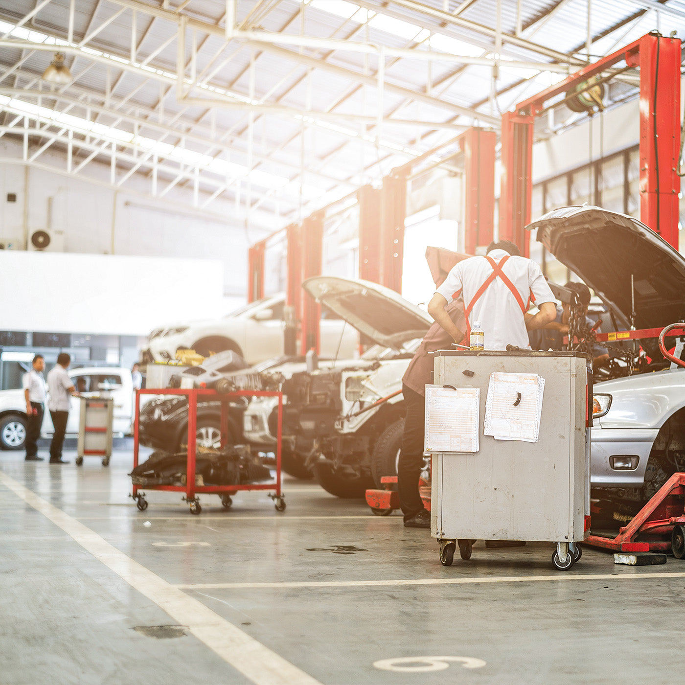 Mechaniker arbeiten an einem Auto in einer großen Werkstatt